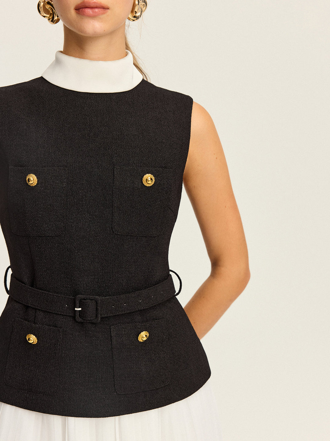 kolsuz, kemerli yelek ve pileli etek takımı