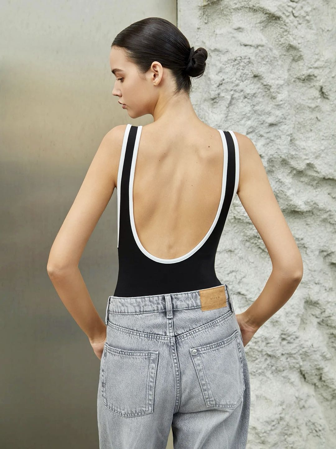 Kenar renk kontrastlı sırtı açık bodysuit, şık ve modern tasarım